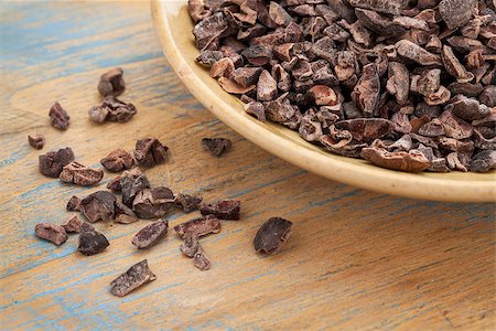 ponta de caneta - Raw cacao nibs in a small ceramic bowl against grunge wooden background Foto de stock - Royalty-Free Super Valor e Assinatura, Número: 400-06742886