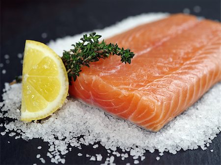 salmon pink - Photo of a raw salmon steak with thyme, lemon slice, on a bed of sea salt and black slate. Stock Photo - Budget Royalty-Free & Subscription, Code: 400-06743345