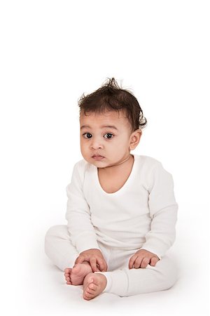 Adorable Indian baby playing with pen over white background Stock Photo - Budget Royalty-Free & Subscription, Code: 400-06758925