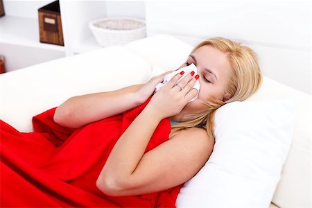 Sick woman lying in bed blowing her nose Stock Photo - Budget Royalty-Free & Subscription, Code: 400-06759421