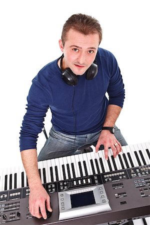 synthesizer - Musician looking at the camera while playing on the keyboard Stock Photo - Budget Royalty-Free & Subscription, Code: 400-06759468