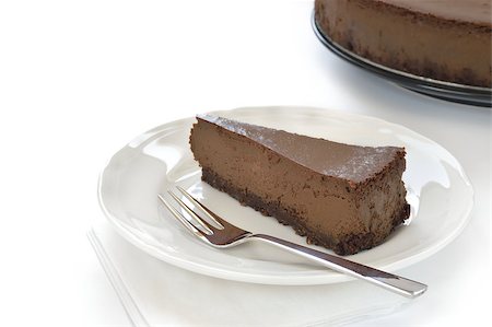 simsearch:400-04468999,k - Slice of chocolate cheesecake on white plate. Cheesecake made of cheese, cream, dark chocolate and some espresso and amaretto. Crust made of almond and biscuits. Stock Photo - Budget Royalty-Free & Subscription, Code: 400-06759489