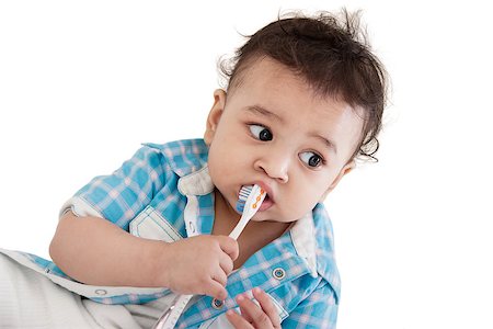 Adorable Indian baby brushing teeth over white background Stock Photo - Budget Royalty-Free & Subscription, Code: 400-06759502