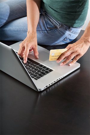 simsearch:400-04442555,k - woman sitting on brown table typing on laptop Photographie de stock - Aubaine LD & Abonnement, Code: 400-06759519