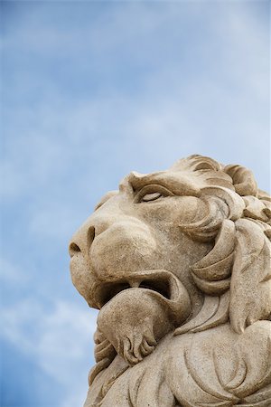 dbvirago (artist) - Stone statue of a lion under a nice blue sky Fotografie stock - Microstock e Abbonamento, Codice: 400-06751070