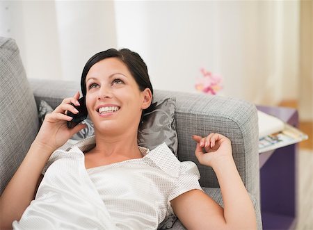 simsearch:400-08054488,k - Happy young woman laying on couch and talking mobile phone Stock Photo - Budget Royalty-Free & Subscription, Code: 400-06751570