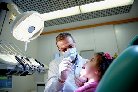 Doctor during visit of female child in dental clinic, dentist checking teeth of young baby girl Stock Photo - Budget Royalty-Free & Subscription, Code: 400-06751822