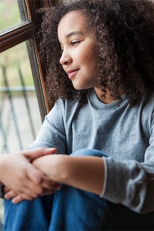 Beautiful young mixed race African American girl sitting smiling and looking out of a rain covered window Stock Photo - Budget Royalty-Free & Subscription, Code: 400-06752049