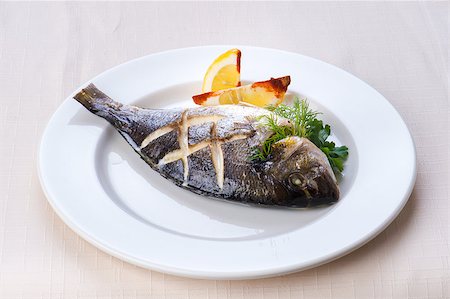 one servings of fish with lemon on white plate Fotografie stock - Microstock e Abbonamento, Codice: 400-06764809