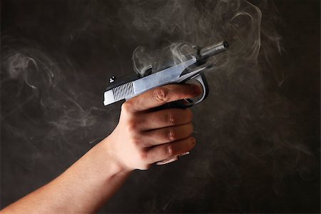 Man's hand a pistol on a dark background with a smoke Stock Photo - Budget Royalty-Free & Subscription, Code: 400-06764899