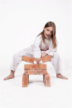 Karate girl in kimono breaks bricks with his hand, isolated on white background Stock Photo - Budget Royalty-Free & Subscription, Code: 400-06766450