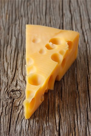 Piece of cheese on an old wooden board. Stock Photo - Budget Royalty-Free & Subscription, Code: 400-06767707