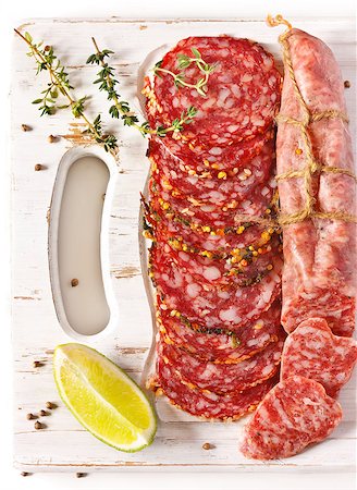 simsearch:400-06082979,k - Variety of salami and spices on a white cutting board. Photographie de stock - Aubaine LD & Abonnement, Code: 400-06767711