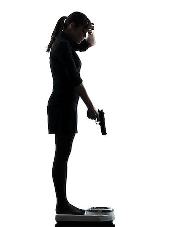 one woman standing on weight scale despair aiming gun silhouette studio isolated on white background Photographie de stock - Aubaine LD & Abonnement, Code: 400-06768298