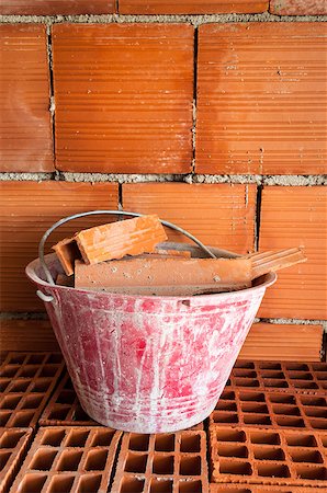 Masonry Red bucket on hollow bricks with in a work site Stockbilder - Microstock & Abonnement, Bildnummer: 400-06769411