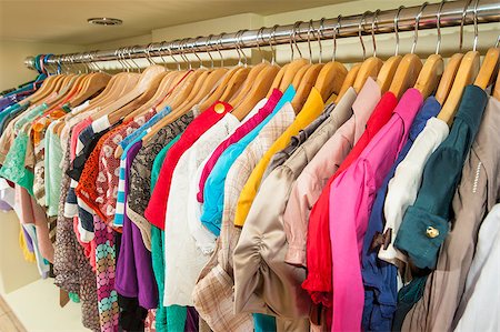 Various multi-colored items of clothing hanging on hangers and rail in a shop Stock Photo - Budget Royalty-Free & Subscription, Code: 400-06769786