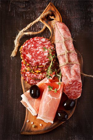 simsearch:400-06565344,k - Variety of salami and ham with olives and spices on wooden background Foto de stock - Super Valor sin royalties y Suscripción, Código: 400-06761880