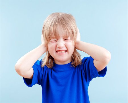 simsearch:400-06763387,k - upset boy with long blond hair covering his ears as protection - isolated on blue Stock Photo - Budget Royalty-Free & Subscription, Code: 400-06763383