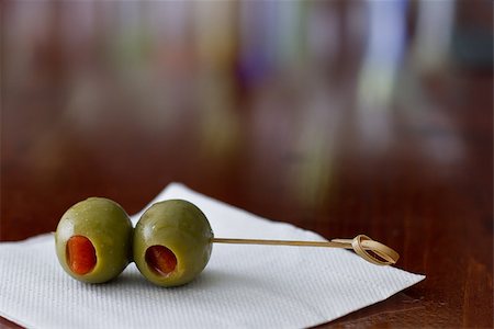 closeup of cocktail olives sitting on a white bar napkin with a shallow depth of field on a busy bar Stock Photo - Budget Royalty-Free & Subscription, Code: 400-06763720