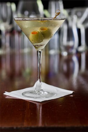 dirty martini - dirty martini chilled and served on a busy bar top with a shallow depth of field and color lights and glasses in the background Stock Photo - Budget Royalty-Free & Subscription, Code: 400-06763721