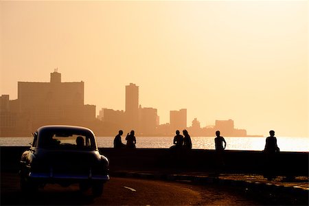 Skyline in La Habana, Cuba, at sunset, with vintage cars on the street and people sitting on the Malecon. Copy space Foto de stock - Super Valor sin royalties y Suscripción, Código: 400-06770212