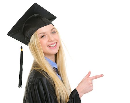 simsearch:400-06772308,k - Smiling young woman in graduation gown pointing on copy space Stockbilder - Microstock & Abonnement, Bildnummer: 400-06772954