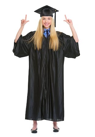 simsearch:400-06772308,k - Full length portrait of happy young woman in graduation gown pointing up on copy space Stockbilder - Microstock & Abonnement, Bildnummer: 400-06772995