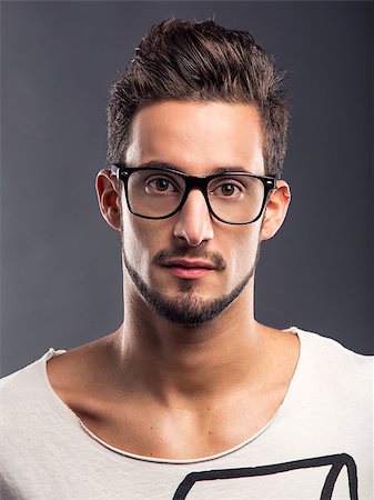 Casual portrait of a hansome young man wearing glasses, looking to the camera Stock Photo - Budget Royalty-Free & Subscription, Code: 400-06788398
