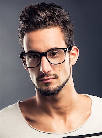 Casual portrait of a hansome young man wearing glasses, looking to the camera Stock Photo - Budget Royalty-Free & Subscription, Code: 400-06788399