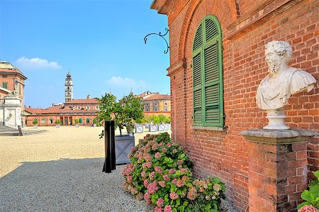 Bust on pedestal on the gravel pathway next to red brick house at the entrance to park and Royal Castle of Racconigi in Piedmont, Northern Italy. Stock Photo - Budget Royalty-Free & Subscription, Code: 400-06789386