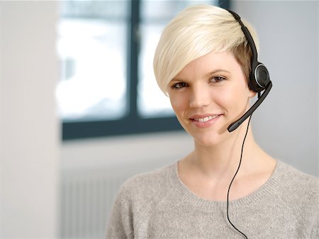 Photo of a cute young call center female with short blond hair and big smile wearing a headset. Stock Photo - Budget Royalty-Free & Subscription, Code: 400-06789381