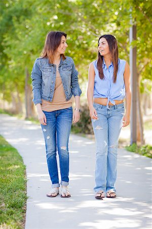 simsearch:400-05734883,k - Young Adult Mixed Race Twin Sisters Walking Together Outside. Stock Photo - Budget Royalty-Free & Subscription, Code: 400-06789712