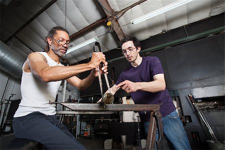 Assistant helping glass manufacturing worker with pliers Stock Photo - Budget Royalty-Free & Subscription, Code: 400-06794019