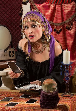 person holding crystal ball - Nervous Caucasian female fortune teller with tarot cards Stock Photo - Budget Royalty-Free & Subscription, Code: 400-06794033