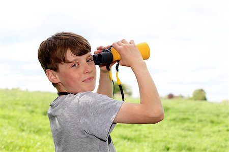 simsearch:400-06744095,k - Young boy in a meadow looking through binoculars Stock Photo - Budget Royalty-Free & Subscription, Code: 400-06794211