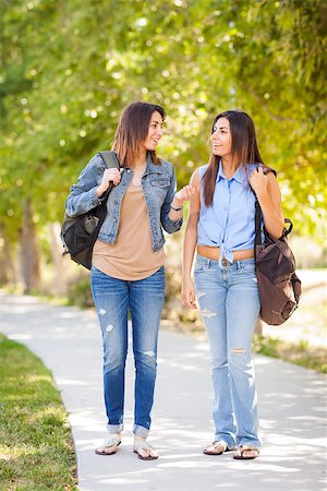 simsearch:400-05734883,k - Young Adult Mixed Race Twin Sisters Walking Together Wearing Backpacks Outside. Stock Photo - Budget Royalty-Free & Subscription, Code: 400-06794524