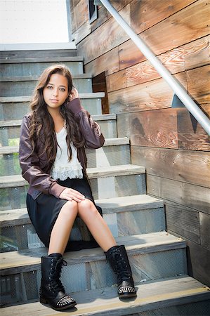 Portrait of a Pretty Mixed Race Young Adult Woman Sitting on a Staircase Wearing Leather Boots and Jacket. Stock Photo - Budget Royalty-Free & Subscription, Code: 400-06794528