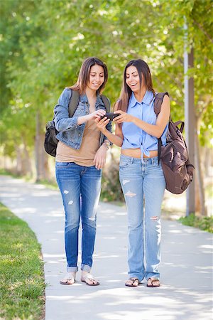 simsearch:400-05734883,k - Young Adult Mixed Race Twin Sisters Sharing Cell Phone Experience Outside. Stock Photo - Budget Royalty-Free & Subscription, Code: 400-06794521