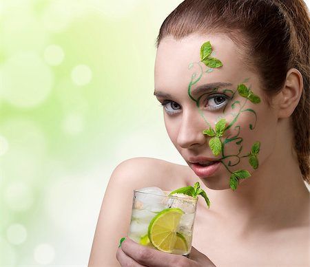 close-up portrait of pretty girl with green creative make-up and some mint leaves on the face, drinking mojito Stock Photo - Budget Royalty-Free & Subscription, Code: 400-06795076