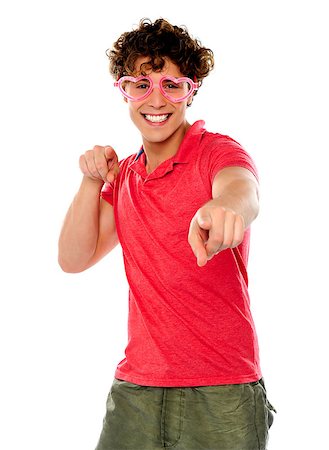 simsearch:400-06795514,k - Handsome guy pointing at camera wearing heart shape pink glasses Photographie de stock - Aubaine LD & Abonnement, Code: 400-06795519