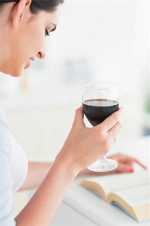 Woman holding a wine glass while reading a book in a kitchen Stock Photo - Budget Royalty-Free & Subscription, Code: 400-06799396
