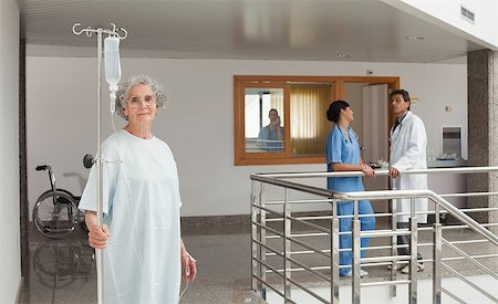 simsearch:400-06799497,k - Old woman standing in the hallway in a hospital holding a drip Stockbilder - Microstock & Abonnement, Bildnummer: 400-06799499