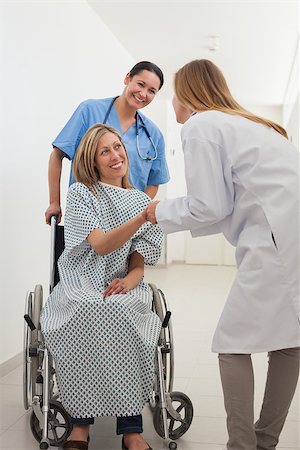 patient walking hospital halls - Smiling female patient shaking hand of doctor with nurse in hospital corridor Foto de stock - Super Valor sin royalties y Suscripción, Código: 400-06799595