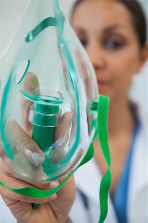 photo of patient in hospital in usa - Female doctor holding up oxygen mask as if to put on patient in hospital Stock Photo - Budget Royalty-Free & Subscription, Code: 400-06799644