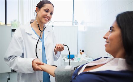 Doctor checking female patient's blood pressure in hospital room Stock Photo - Budget Royalty-Free & Subscription, Code: 400-06799647