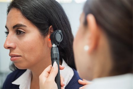 simsearch:400-06875952,k - Doctor using otoscope instrument to check woman's ear in hospital Stockbilder - Microstock & Abonnement, Bildnummer: 400-06799652
