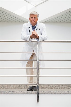 Smiling doctor leaning on rail in hospital corridor Stock Photo - Budget Royalty-Free & Subscription, Code: 400-06799660