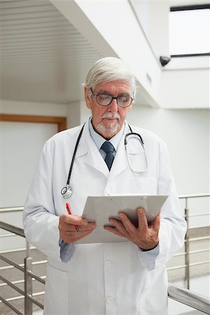 Doctor looking at patient files in hospital corridor Stock Photo - Budget Royalty-Free & Subscription, Code: 400-06799674