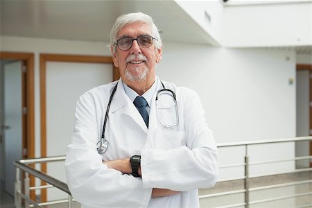 Doctor standing on the corridor smiling with arms crossed Stock Photo - Budget Royalty-Free & Subscription, Code: 400-06799677