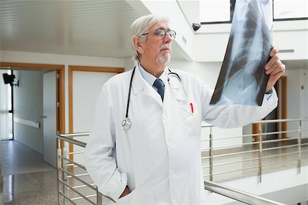 Doctor standing on the corridor looking at a x-ray in a hospital Stock Photo - Budget Royalty-Free & Subscription, Code: 400-06799679